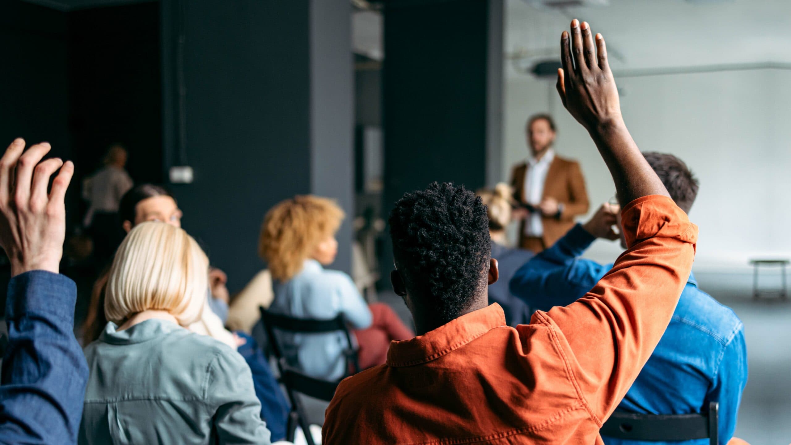 Person raises their hand in classroom setting